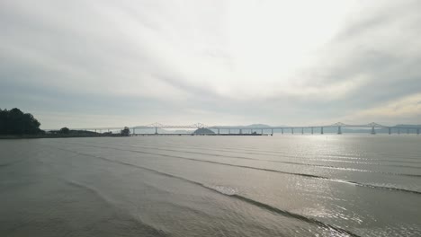 the richmond–san rafael bridge, with its towering structure, rises above the bay near point molate beach in richmond.