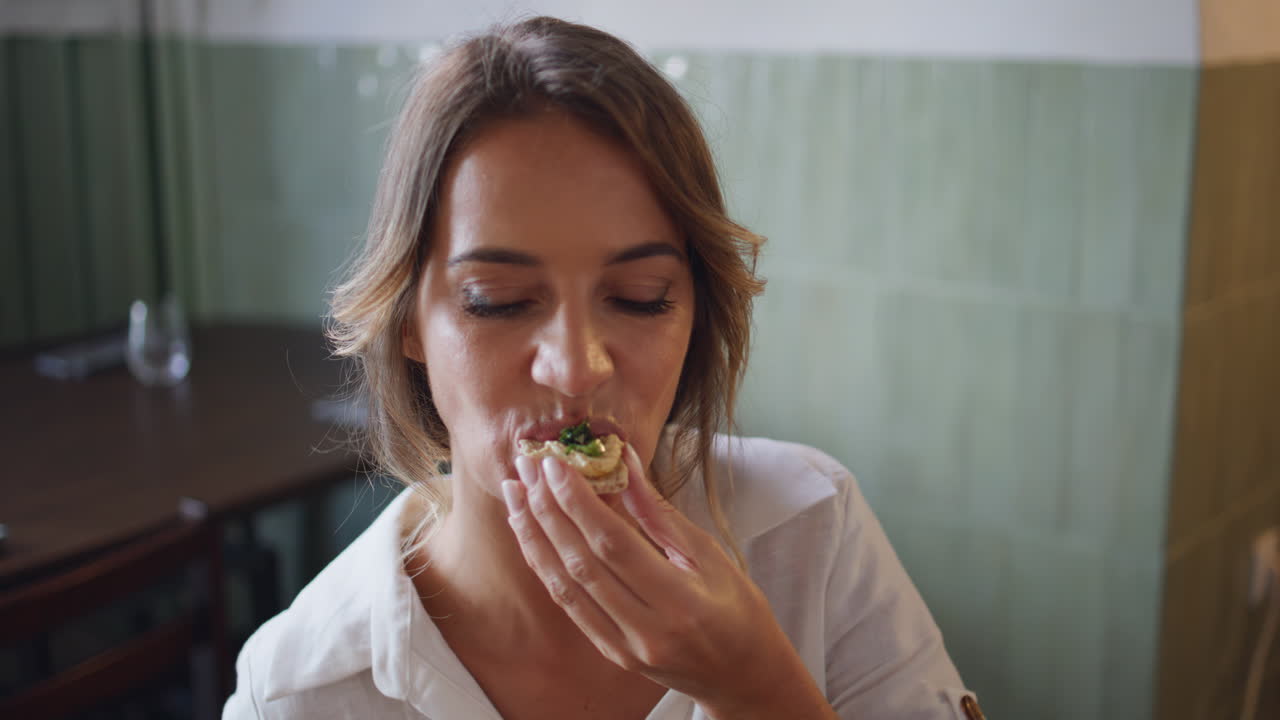 브루체타 레스토랑을 가까이서 먹는 금발 여인. 만족한 여성이 식사를 고 있다.