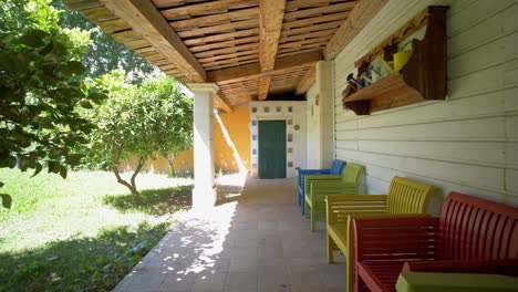 slow dolly shot revealing colourful wooden chairs under a villa patio