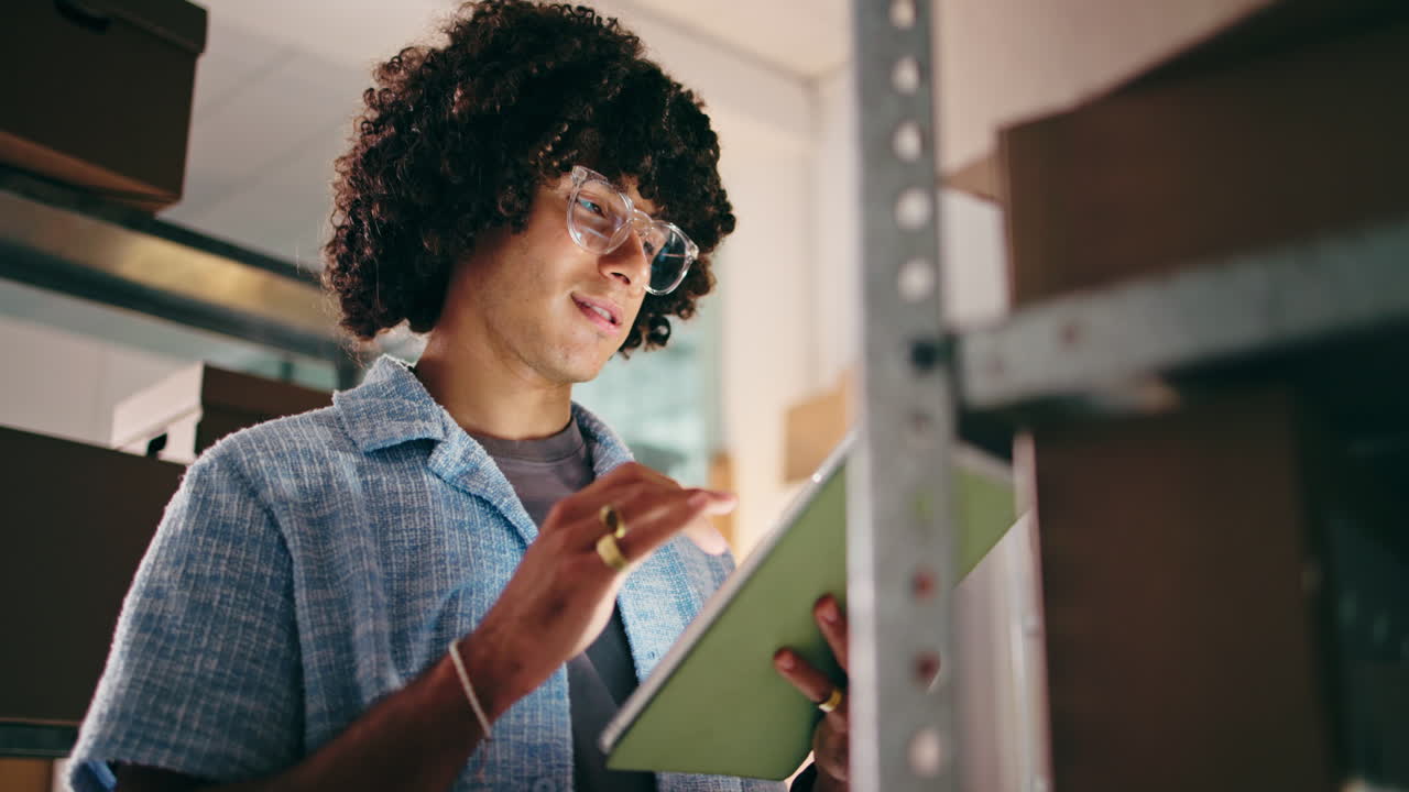 Young Man Checking Inventory on Tablet in Warehouse
