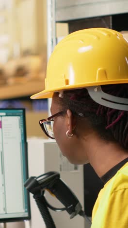 vertical video african american warehouse clerk oversees package route to update tracking info