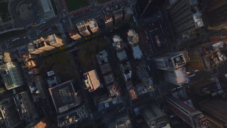 Aerial-birds-eye-overhead-top-down-panning-view-of-city-development.-Blocks-of-buildings-surrounded-by-streets-in-autumn-city.-Manhattan,-New-York-City,-USA