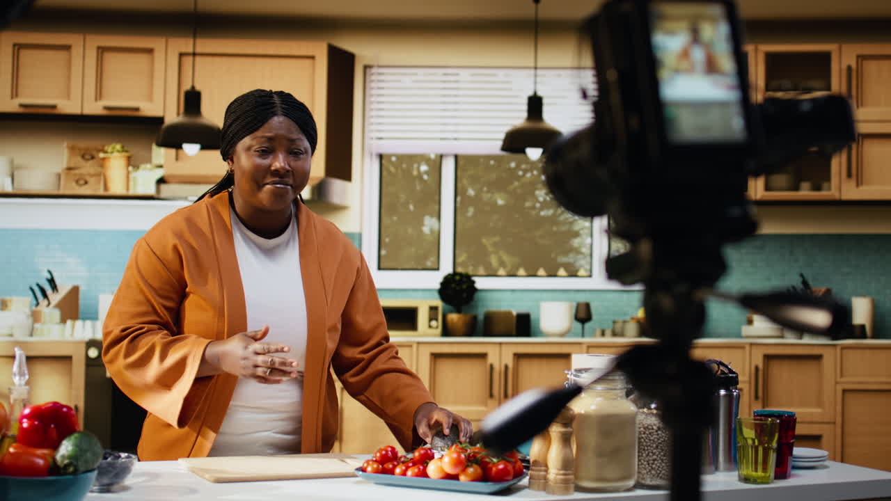 Food influencer, donna afroamericana, che controlla le impostazioni della fotocamera, mentre gira un video