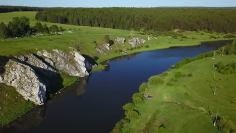 aerial view of a river winding through a valley with rocky banks and lush green landscape