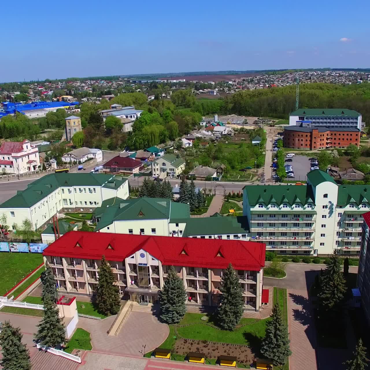 Colorful architecture of the provincial city on sunny summer day. Town with lush greenery from top view