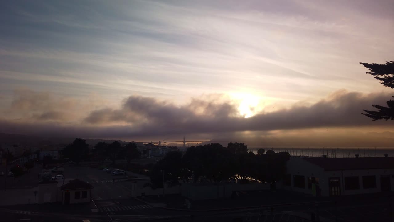 tiro estático cardán de niebla rodando sobre el puente golden gate desde fort mason al atardecer en san francisco, california