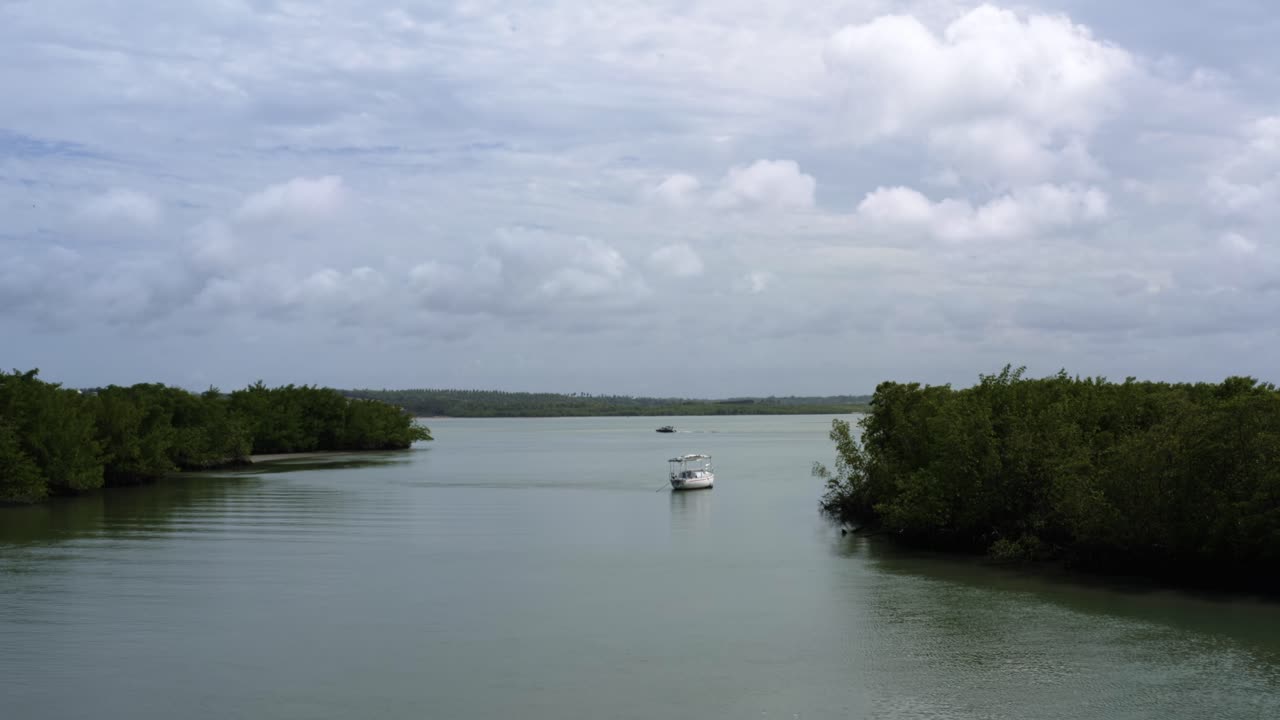 Aerial drone shot of an abandoned sail boat anchored in the tropical Guara&iacute;ras Lagoon surrounded by mangrove forests near Tibau do Sul, Brazil in Rio Grande do Norte on a warm sunny summer day
