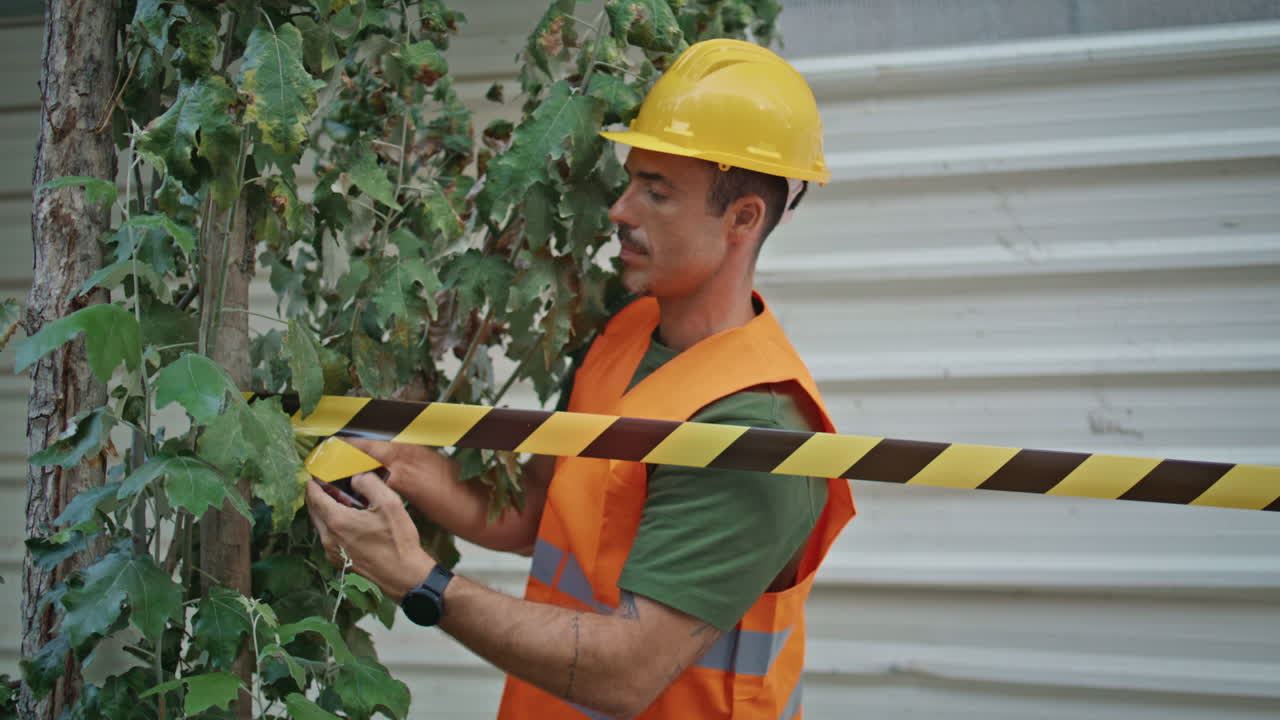 Uniform man attaching tape at renovation site place closeup. Foreman working