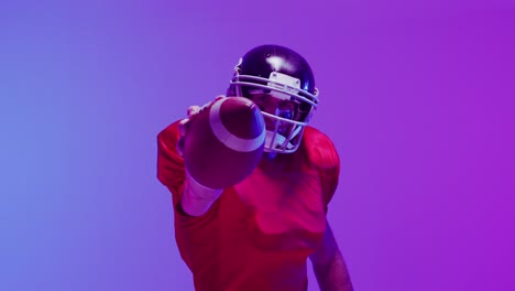 video of caucasian american football player in helmet with ball over neon purple background