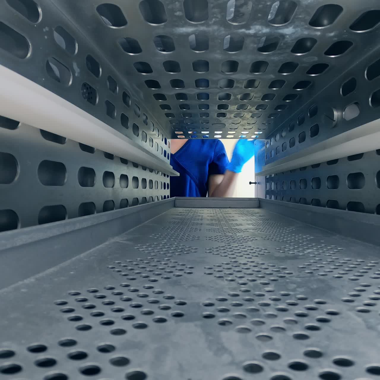 Instrument in plastic bag lies in the sterilizer. Female medic opens the doors and takes away the sterilized tool from the machine