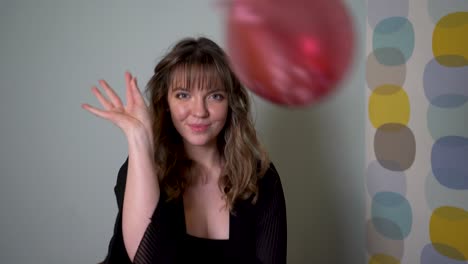 mujer joven sentada en una mesa rodeada de globos