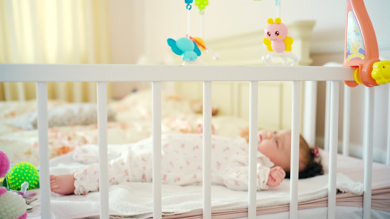 Neonato sereno che dorme nella culla in una luminosa cameretta.