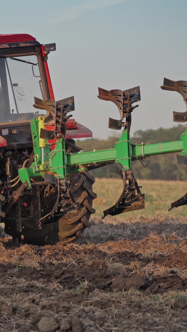 Tractor plowing land. View of red tractor in the agricultural field