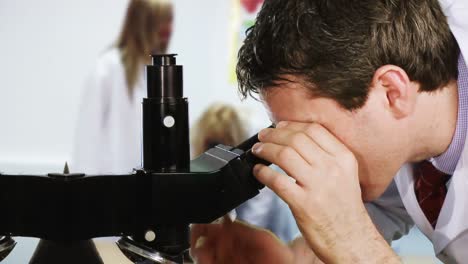 Researcher-looking-into-a-microscope