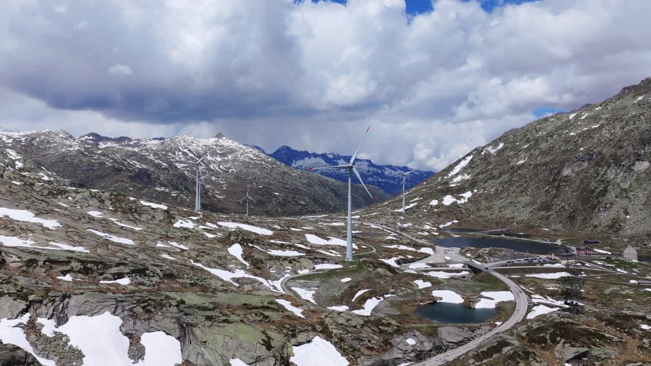 vehículos que conducen por el paso de gotthard con vistas a las turbinas eólicas en un parque eólico en suiza