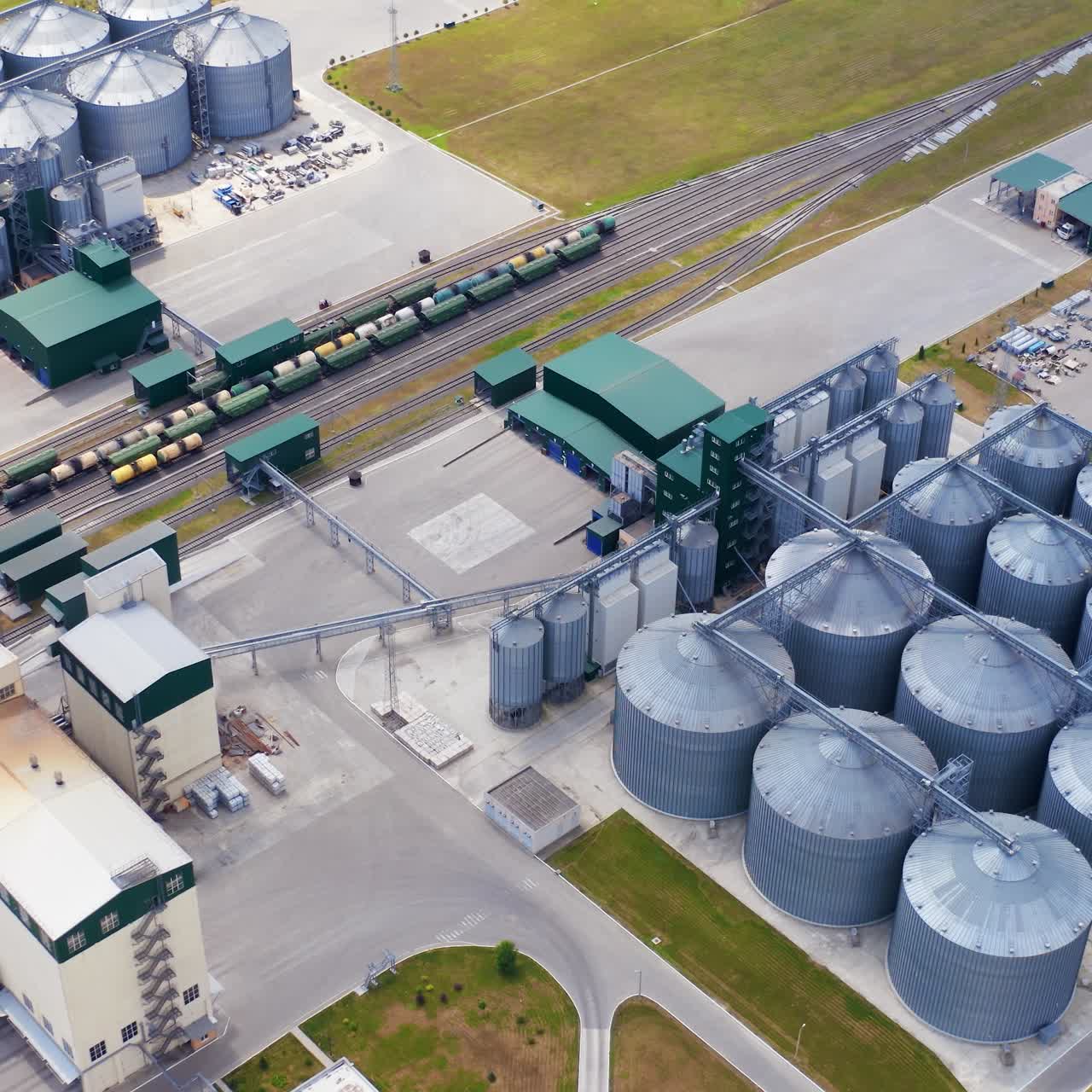 Grain elevators on field. Modern industry for agribusiness. Grain drying complex with large bins. Grain storage tanks. Aerial view