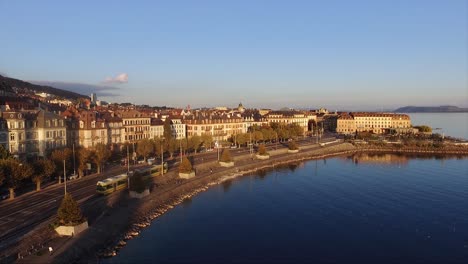 aerial view of the tramway in the city of neuchâtel in switzerland, next to the lake, during sunset in summer