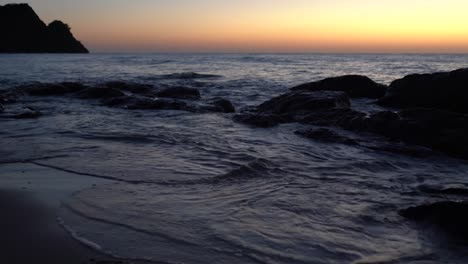 waves gently wash up onto the beach, then recede as the sunset. a beautiful sunset over a sea on turkey
