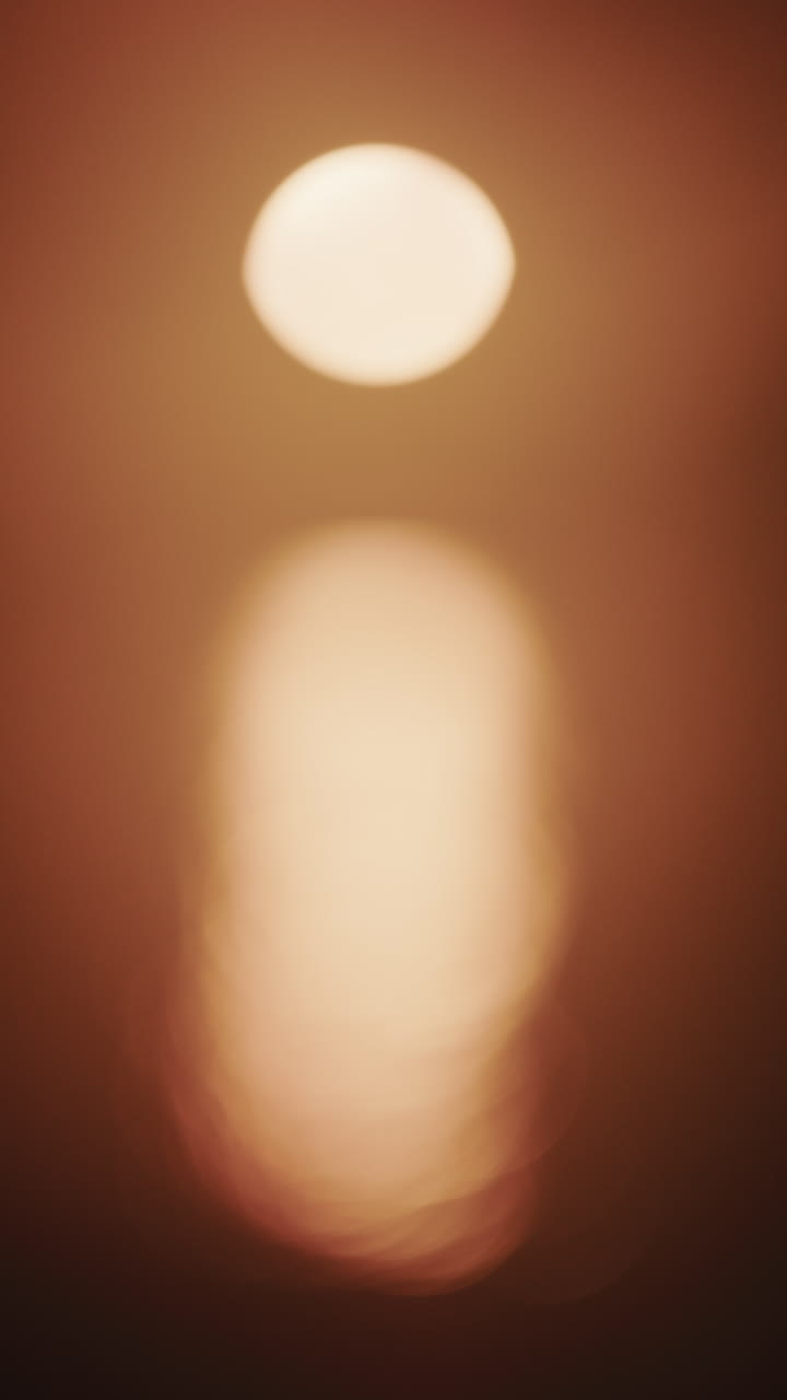 Foto abstrata e fora de foco do sol e seu reflexo no mar. Vertical