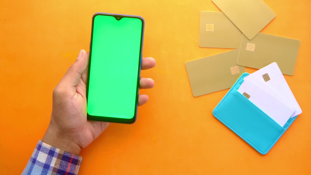 teléfono móvil en la mano con tarjetas de crédito y billetera