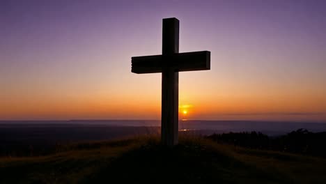 sunrise over a wooden cross on a hilltop