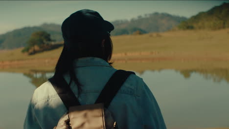 woman hiking by a calm lake