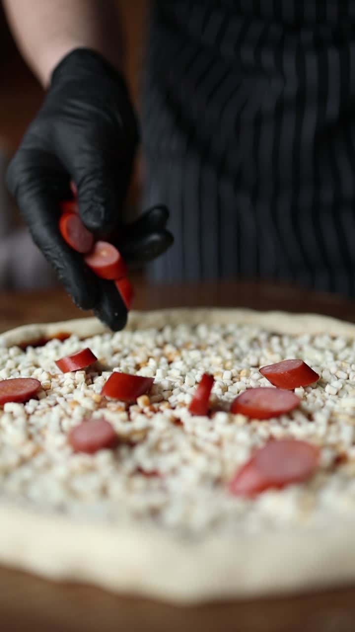 шеф-повар готовит пиццу с колбасой и сыром.