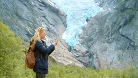 woman taking pictures of glacier in norway