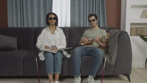 camera zooming on blind friends sitting on a sofa in a flat