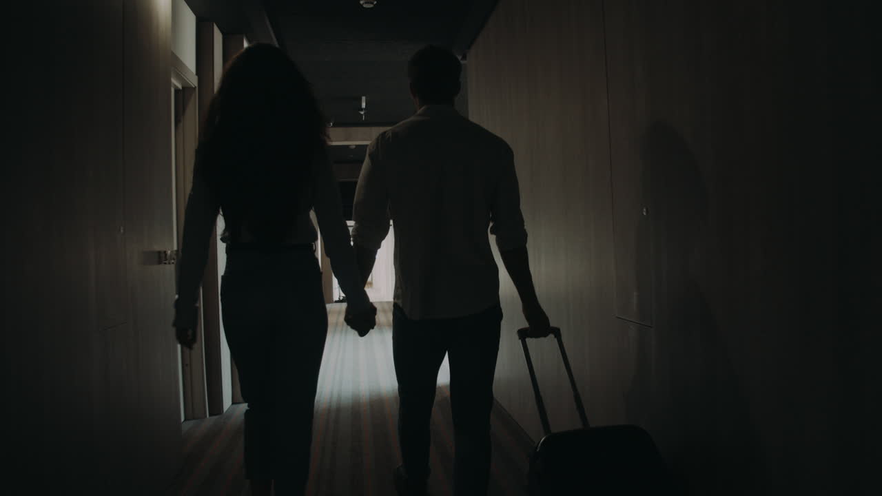 Coppia romantica che cerca la camera d'hotel. Giovane coppia che cammina con la valigia.