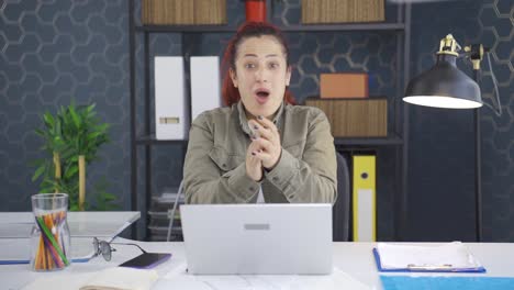 una mujer de negocios emocionada aplaudiendo a la cámara.
