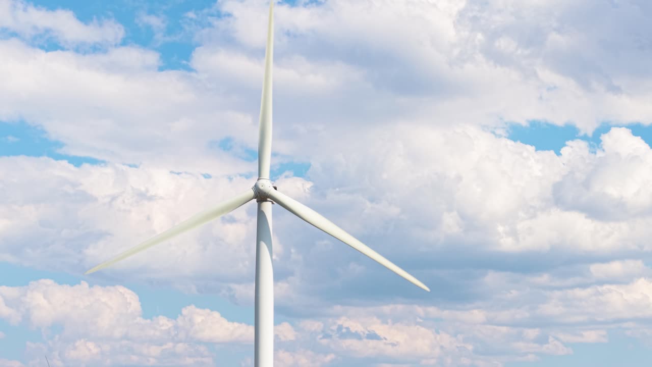 Detailed view of a wind turbine in motion near Shipka. Clean, renewable energy production under clear skies and soft clouds in the Balkan Mountains