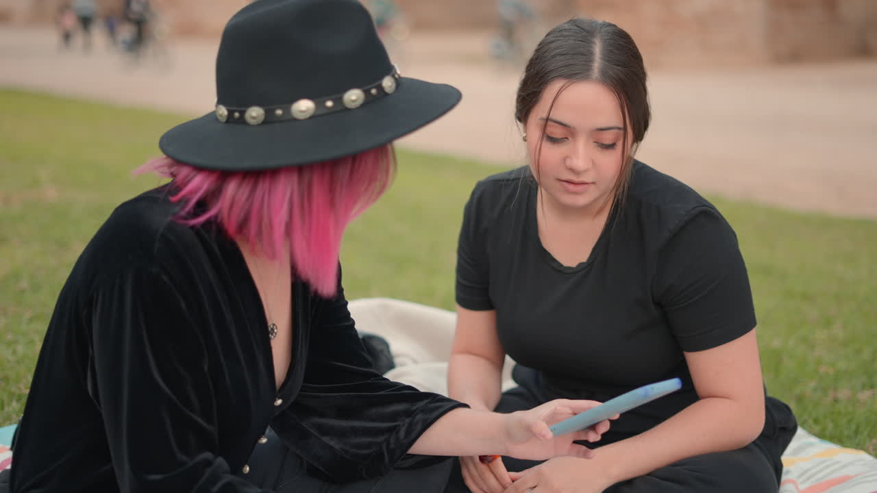 две женщины разговаривают в парке.