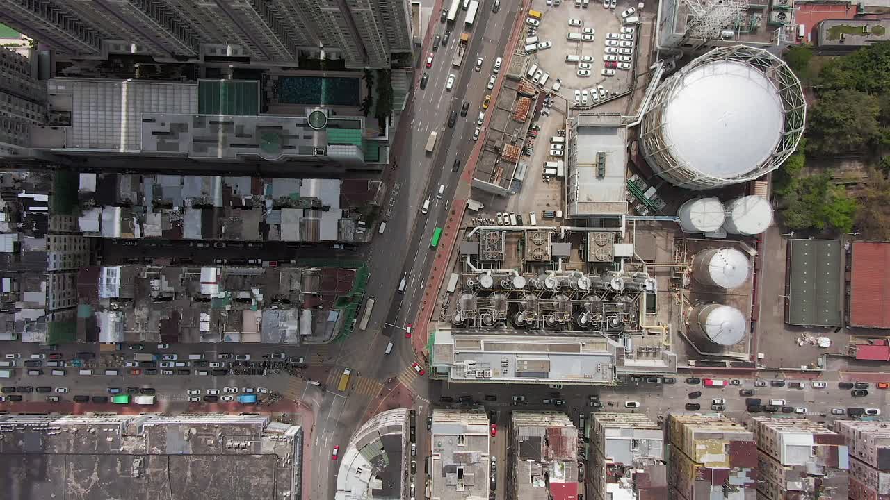 Aerial time lapse of Downtown Hong Kong urban traffic above Kowloon area with slum buildings and Gas industry storage lot