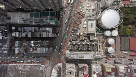 aerial time lapse of downtown hong kong urban traffic above kowloon area with slum buildings and gas industry storage lot