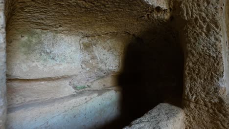 close-up pullback of looking deep inside the dark burial chambers in the tomb of the kings in paphos, cyprus