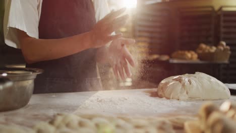 animation of midsection of biracial male baker clapping hands to clean flour at bakery