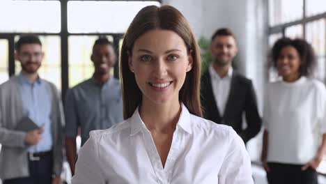 smiling attractive female business leader looking at camera thumbs up