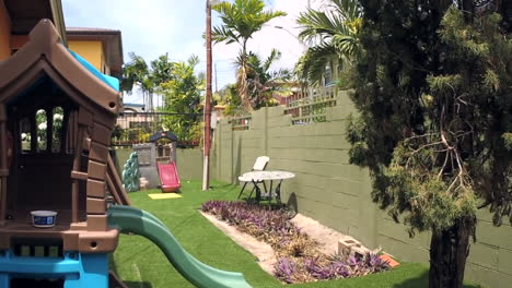 patio trasero con casa de juegos y árboles balanceándose en el viento