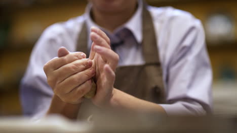 person kneading clay