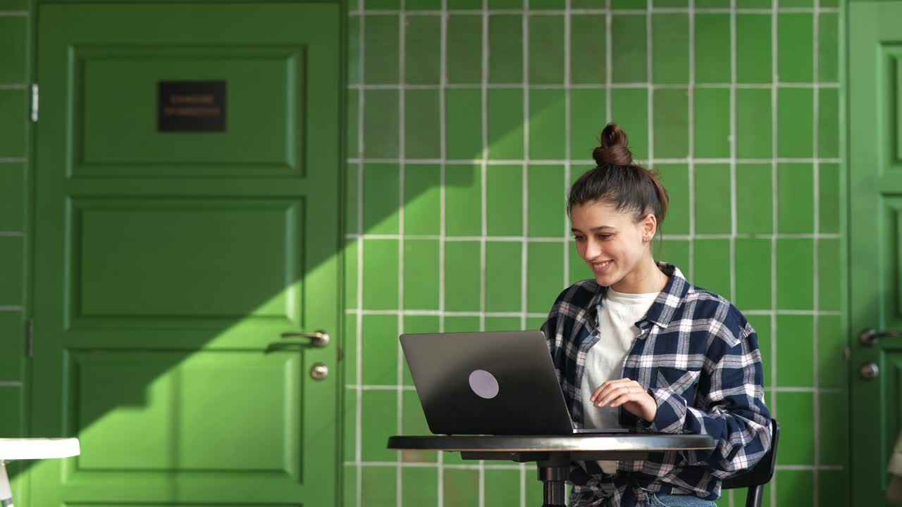 mujer trabajando en una computadora portátil en un café