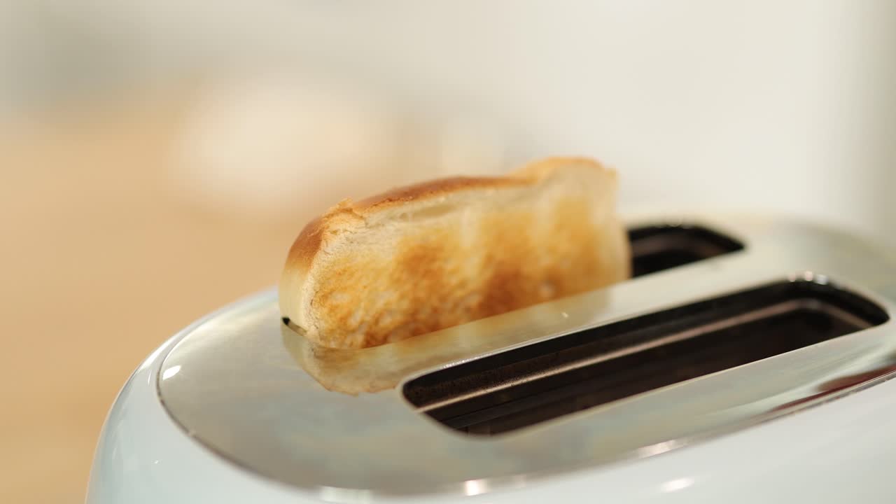 A slice of bread pops from a toaster in a bright kitchen setting, captured in a sequence of frames