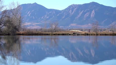 Man-running-along-a-lake-in-slow-motion-against-a-background-of-mountains