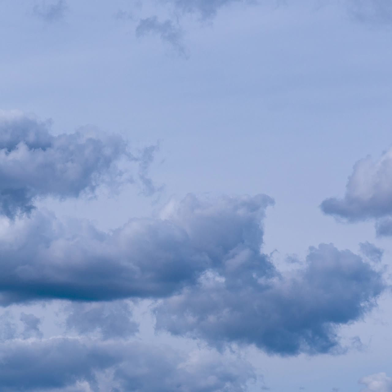 Nasty blue sky with cumulus clouds. Dramatic cloudscape in the atmosphere. Timelapse. Vertical screen