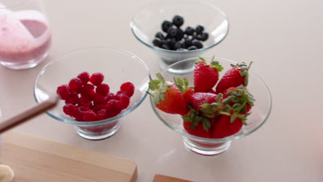 preparing healthy snacks, bowls of fresh berries on kitchen counter