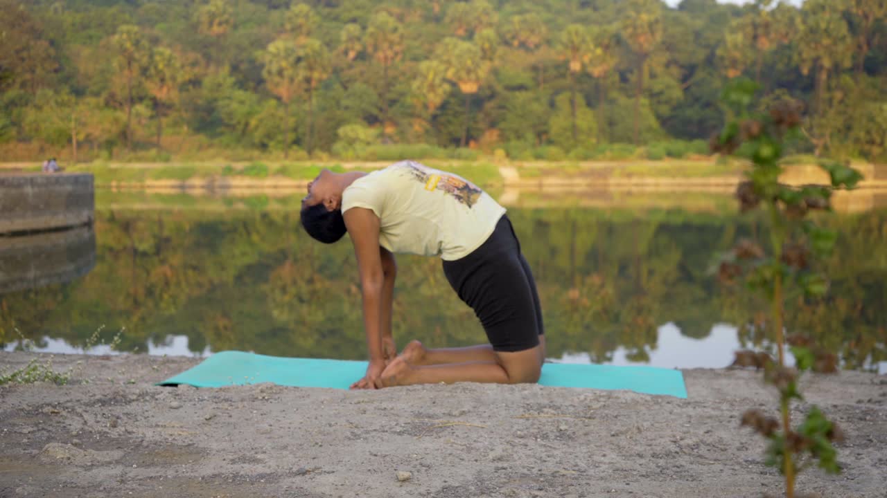 chica india haciendo yoga ustrasan india mumbai backbend plantean yogsana junto al lago de baja profundidad