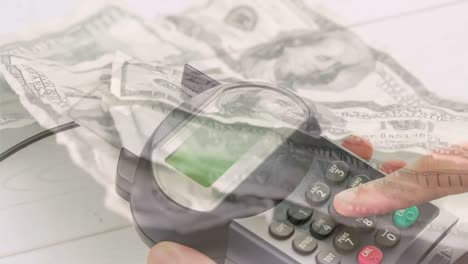 Animation-of-dollar-banknotes-falling-over-hand-of-caucasian-man-holding-payment-terminal