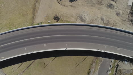 aerial perspective of silver car moving from right to left hand side of frame over new bridge