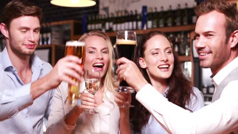 smiling friends toasting together with wine and beer