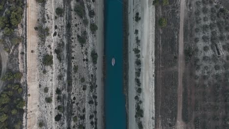 Barco-Que-Cruza-El-Istmo-De-Corinto-Desde-La-Perspectiva-De-Un-Dron,-Proporcionando-Una-Vista-única-De-La-Estrecha-Franja-De-Tierra.